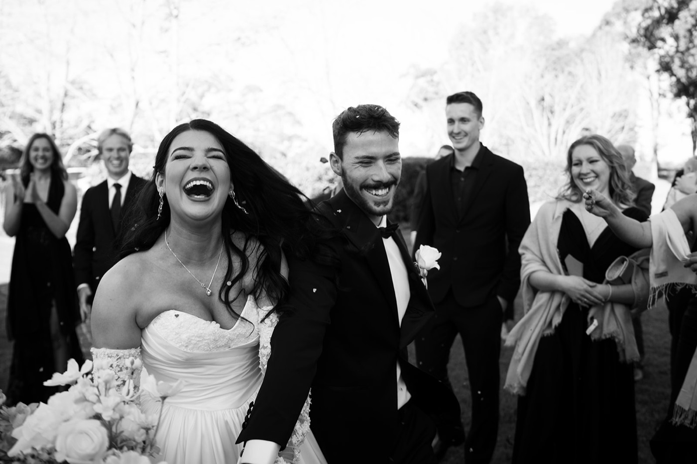 Bride laughing with the bridal party, black and white